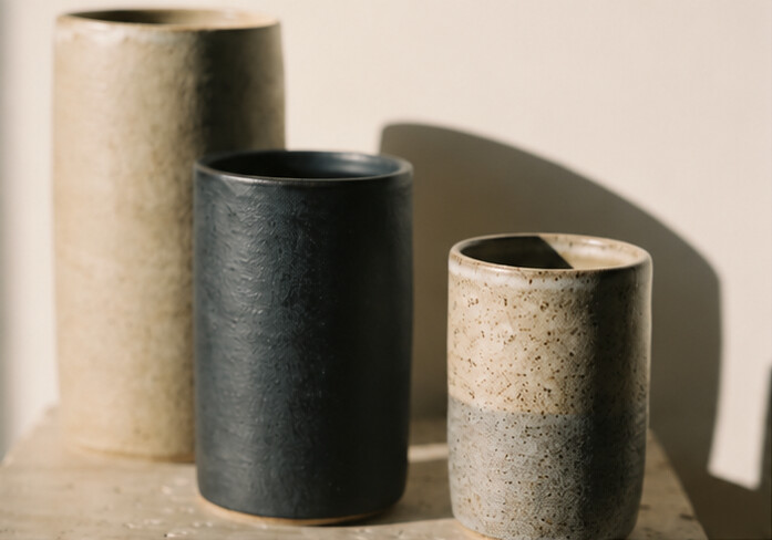 Three stoneware vessels in warm directional light